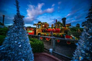 Árvore de natal decorada com trem ao fundo