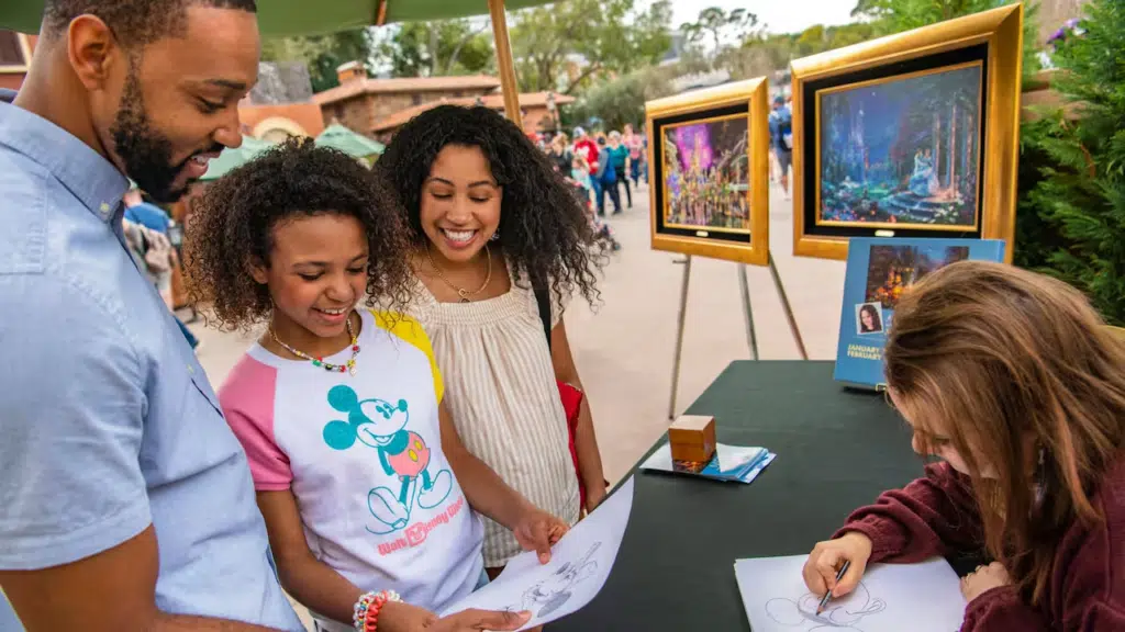 Família admirando artista desenhando personagens da Disney no evento EPCOT International Festival of the Arts