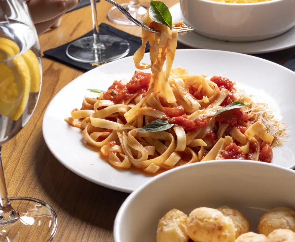 Macarrão do buffet e pão de queijo de entrada da churrascaria brasileira de Orlando Divina Carne