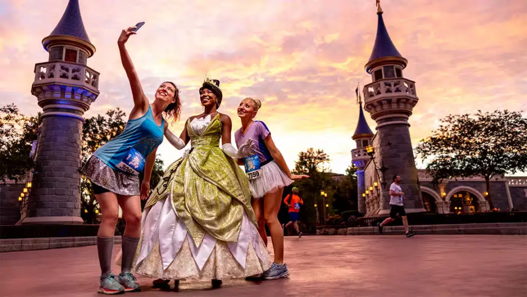 Duas mulheres, participantes do evento runDisney, tiram foto com princesa Tiana 