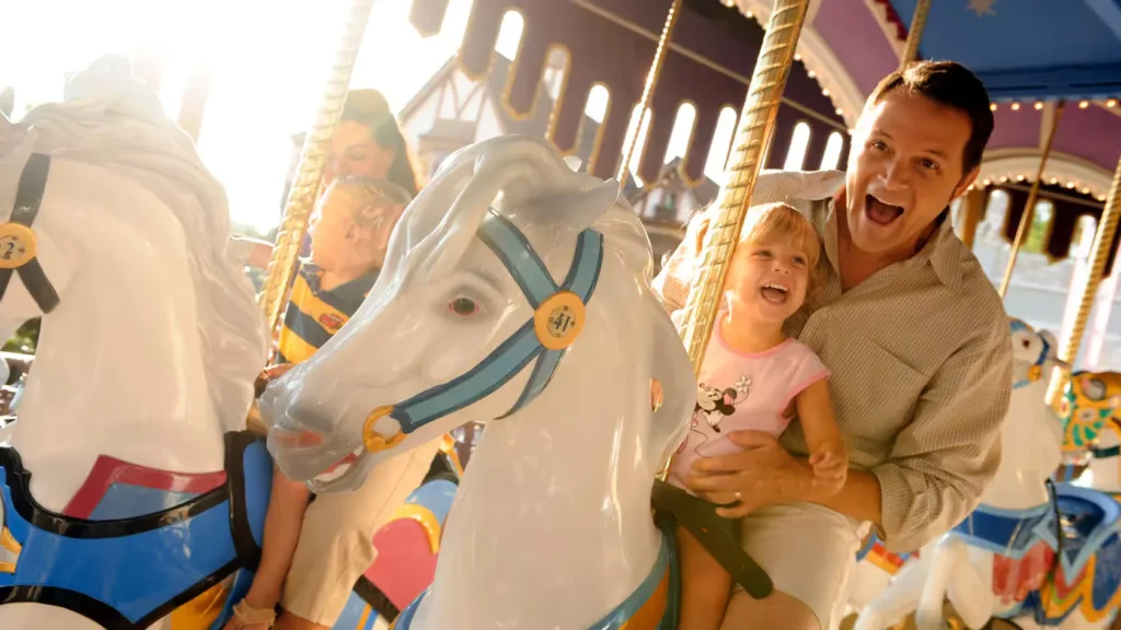 Pai e filha na atração Prince Charming Regal Carrousel - Magic Kingdom